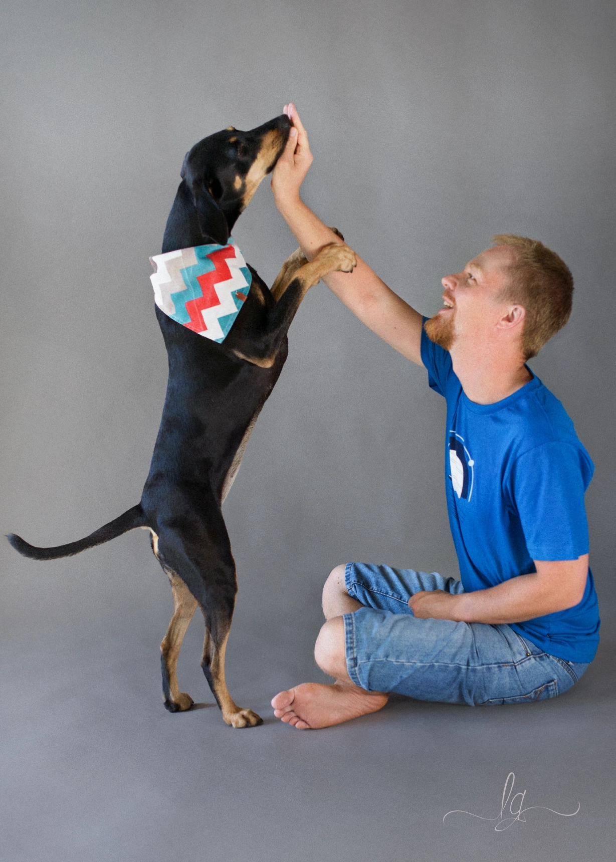 Lacko is playing with dog in studio.