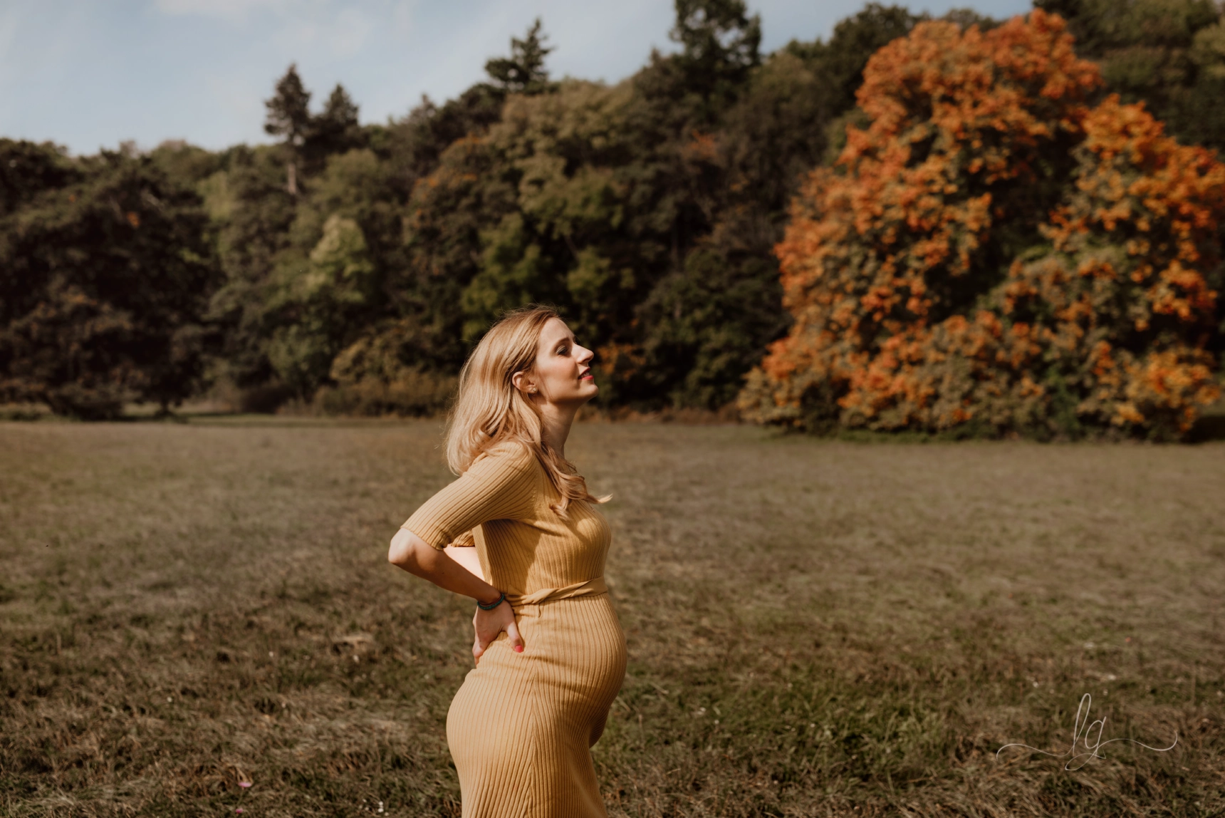 Pregnant woman in yellow dress nature